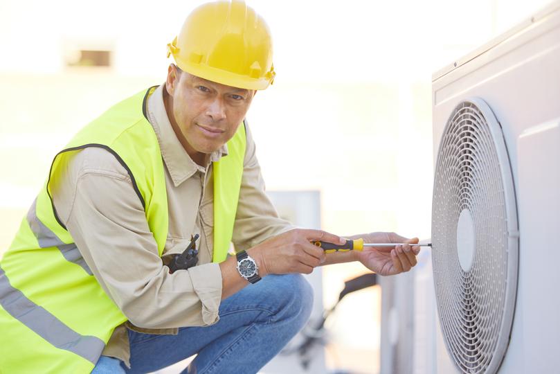 An HVAC technician servicing an air conditioning unit