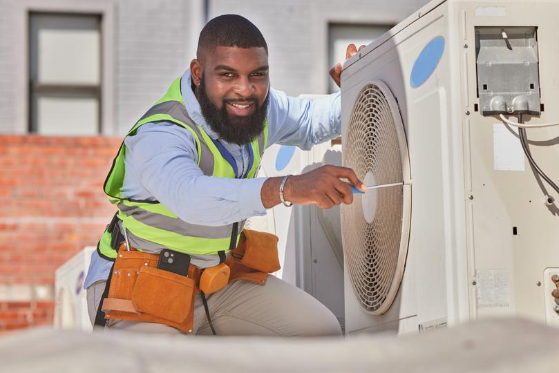 An HVAC technician servicing an air conditioning unit