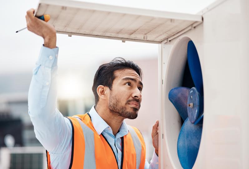 An HVAC technician servicing an air conditioning unit